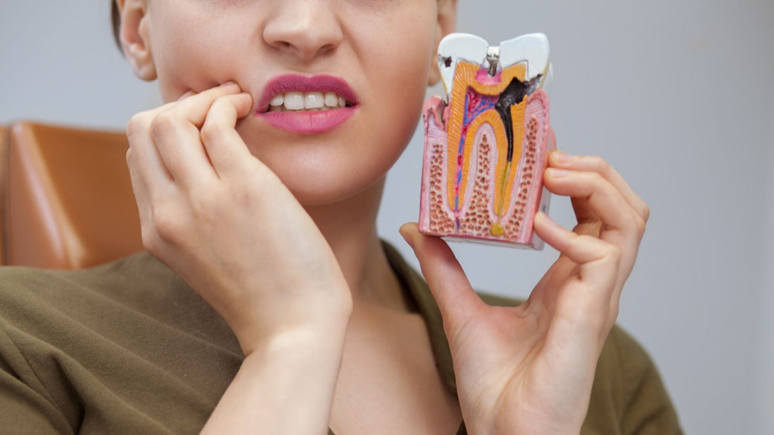 A woman holding tooth decayed model