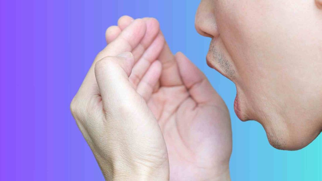 A man smelling his breath